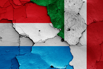 flags of Luxembourg and Italy painted on cracked wall