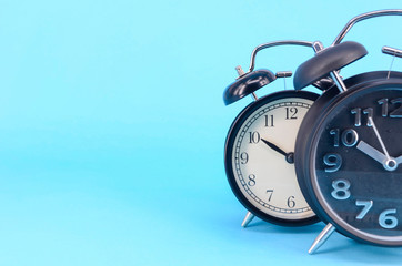 Alarm clock on blue background. Selective focus.