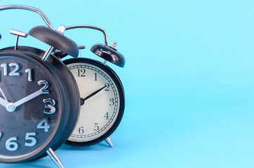 Alarm clock on blue background. Selective focus.
