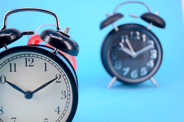 Alarm clock on blue background. Selective focus.