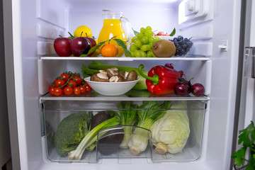 Fototapeta na wymiar Food photography of a clean fridge filled with vegan foods such as fruits vegetables, juices and plant milk