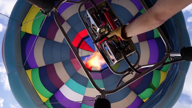 Man inflate air into multicolor air balloon