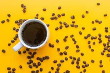 cup of coffee and coffee bean on yellow background. soft focus.