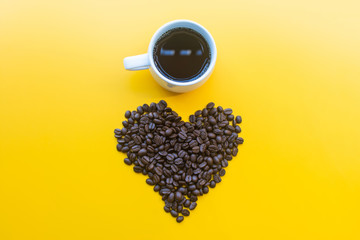 cup of coffee and coffee bean on yellow background. soft focus.