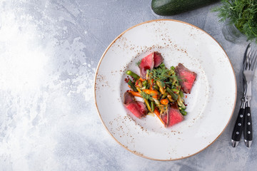 Beef salad with vegetables on a plate. Copy space. Top view