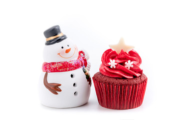Merry Christmas and Happy New Year with red cupcake and snowman statuette