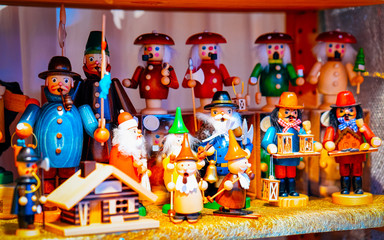 Wooden toys Christmas Tree Decorations on Christmas Market at Gendarmenmarkt in Winter Berlin, Germany. Wood figures on Advent Fair, and Stalls with Crafts Items in Bazaar.