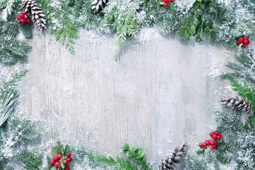 Fototapeta na wymiar Christmas and New Year background with fir branches and snowfall on wooden white board