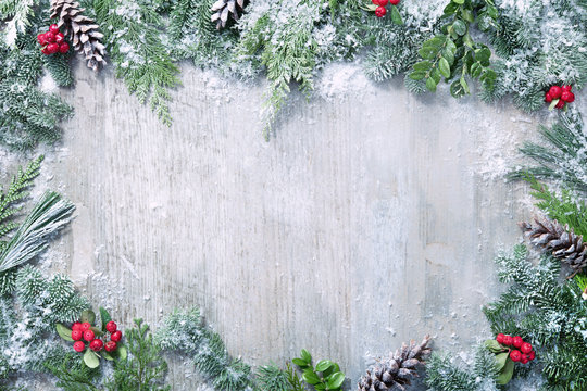 Christmas and New Year background with fir branches and snowfall on wooden white board