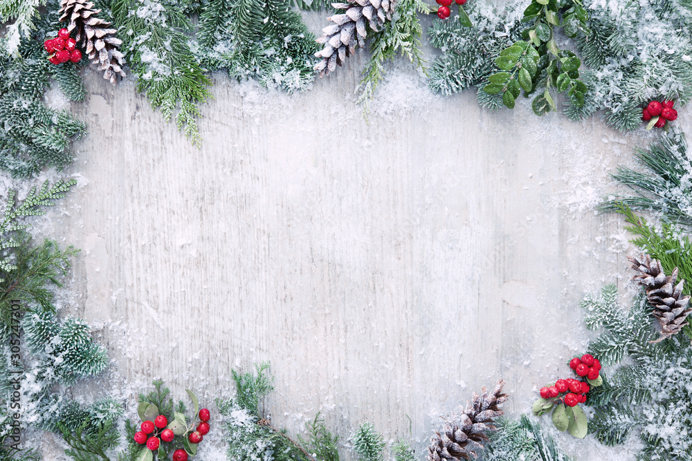 Wall mural christmas and new year background with fir branches and snowfall on wooden white board