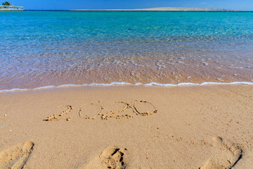 New year 2020. Inscription on a sandy beach. Tropical celebration concept