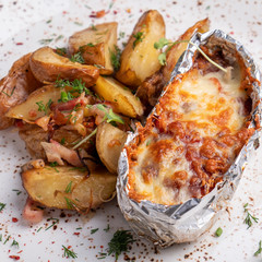 Baked chicken fillet  with tomatoes, mozzarella and greens garnish with potato.