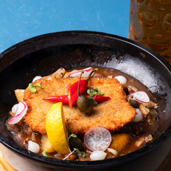 Chicken schnitzel on a frying pan. Closeup