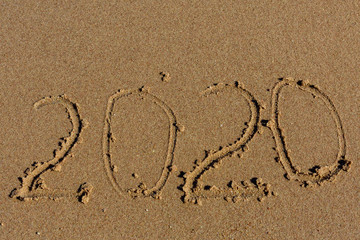 Fototapeta na wymiar New year 2020. Inscription on a sandy beach. Tropical celebration concept