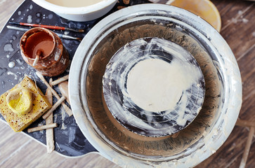 Overview of pottery wheel, sponge and paintbrush for decorative painting by workplace