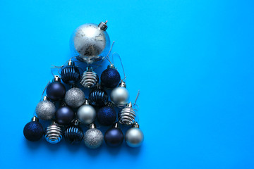 Silver and Blue baubles Christmas decoration on blue background. Flat lay. Copy Space. Holiday concept. Christmas toys, composition.