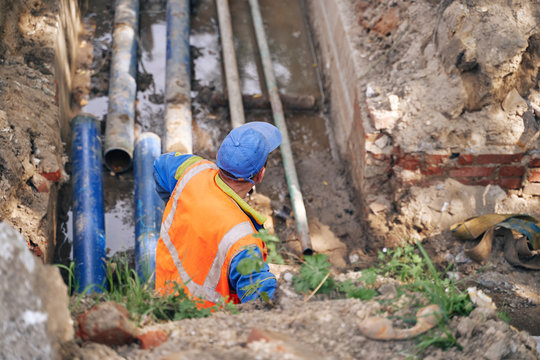 municipal worker serves underground heating pipes