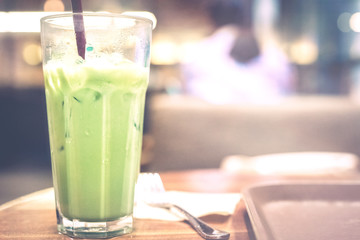 local business and relaxation activity from ice green tea put on wooden table in vintage coffee shop with softfocus background