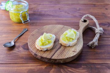 Sandwiches with cucumber jam and lemon on a wooden board.