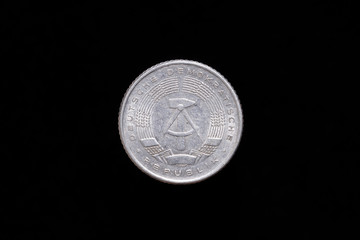 Old German Democratic Republic 50 Pfennig coin from 1958, obverse showing the national emblem of the GDR. Isolated on black background