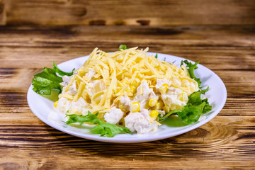 Festive salad with chicken breast, canned pineapple, cheese, sweet corn and mayonnaise on wooden table