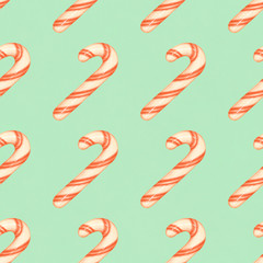 Red and white striped candy canes on a blue background. Christmas seamless pattern with candy canes