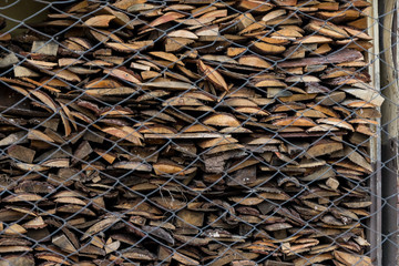Folded in wooden piled beige beech boards, uneven bars (background) in a sawmill. Sawn-off boards