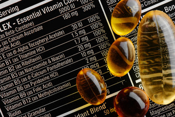 Close-up of a black label with supplements facts of a multivitamin complex, omega-3 gelatin capsules and vitamin D3, medicines