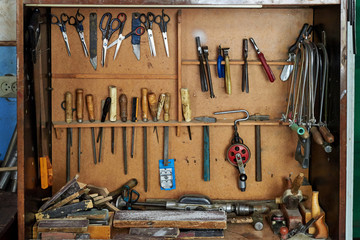 Old carpentry tools on a wooden wall.