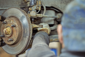 mechanic repairing a car on a car service lift