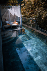 Jeune homme qui se repose au bord d'une piscine