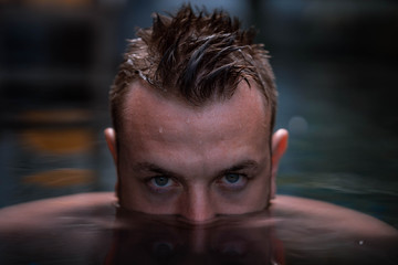 Portrait d'un jeune homme mouillé dans une piscine