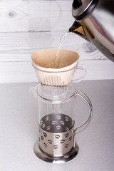 pour boiling water ground coffee placed in a funnel v60, for alternative brewing