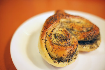 Valentine bun for breakfast for lovers on orange table background