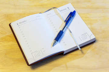 Russian-English datebook and pen lying on the surface of the table. The datebook is open on the first of January. Russia.