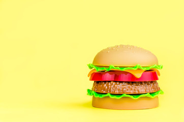 fast food. plastic hamburger on a yellow background