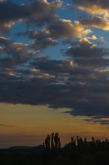 Landscape with dramatic light - beautiful golden sunset with saturated sky and clouds.