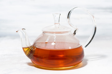 tea in a glass teapot on a white background