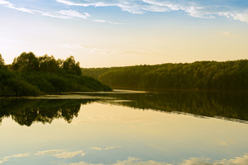 Summer evening landscape with a lake and forest on the shore