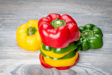 Multi colored bell peppers uniquely stacked on a tabletop