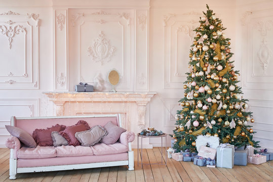 Luxury Living Room Interior With Sofa Decorated Chic Christmas Tree, Gifts And Pillows. Classic Interior In Pink Shades. Christmas At Home. Pink Sofa On Background Of Christmas Tree. Postcard Template