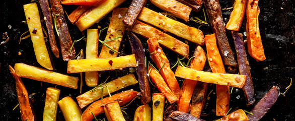 French fries,  baked fries from different types and colors of potatoes sprinkled with herbs and...