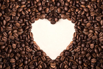 coffee beans on a light background with space for your text in heart shape