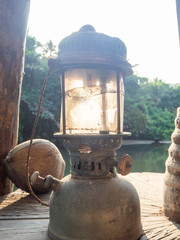 Plakat old oil lamp backlit by the sun