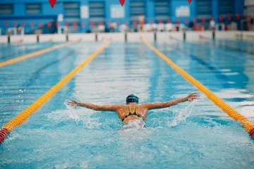 Fotobehang Young woman swimmer swims in swimming pool © primipil