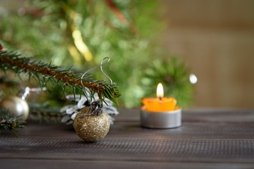 Christmas, decoration on a wooden table. Christmas pine cones and golden Christmas balls. Burning candle