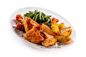 Fried chicken wings with baked potatoes and vegetable salad