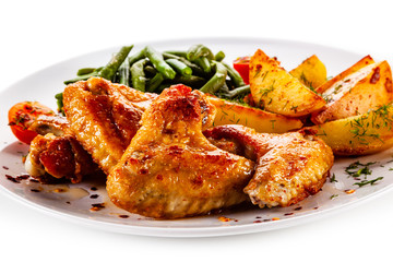 Fried chicken wings with baked potatoes and vegetable salad