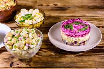Set of festive mayonnaise salads on wooden table
