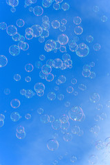 Soap bubbles against blurred blue sky background